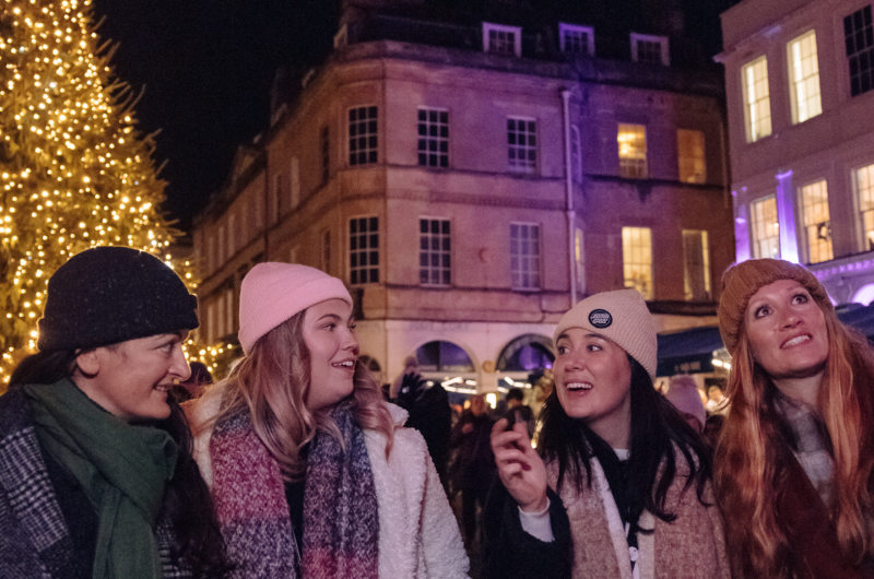 four women standing infront of a christmas tree