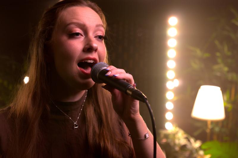 Lowrie singing into microphone