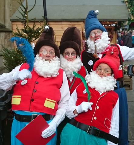 four elves pulling a funny face at christmas market