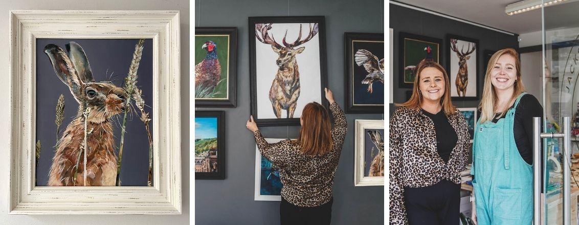 Two people standing beside artwork of animals