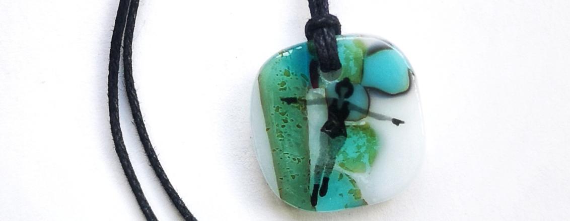 A necklace pendant of a lady swimming